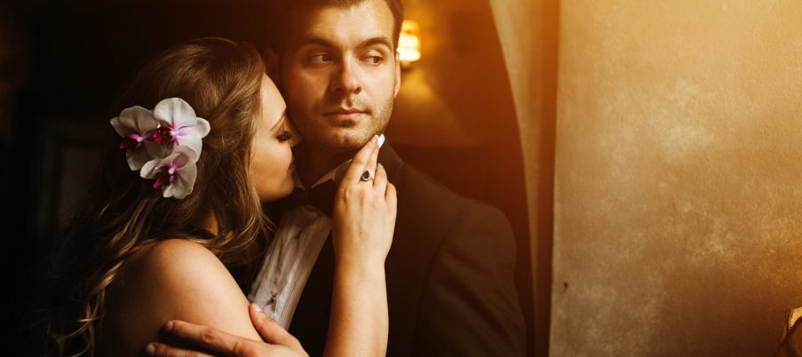 The bride and groom in a cozy house, photo taken with natural light from the window.
