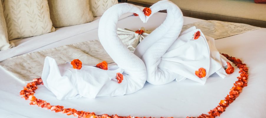 Swan towel and rose flower with beautiful luxury pillow decoration on bed in bedroom interior - Vintage light Filter